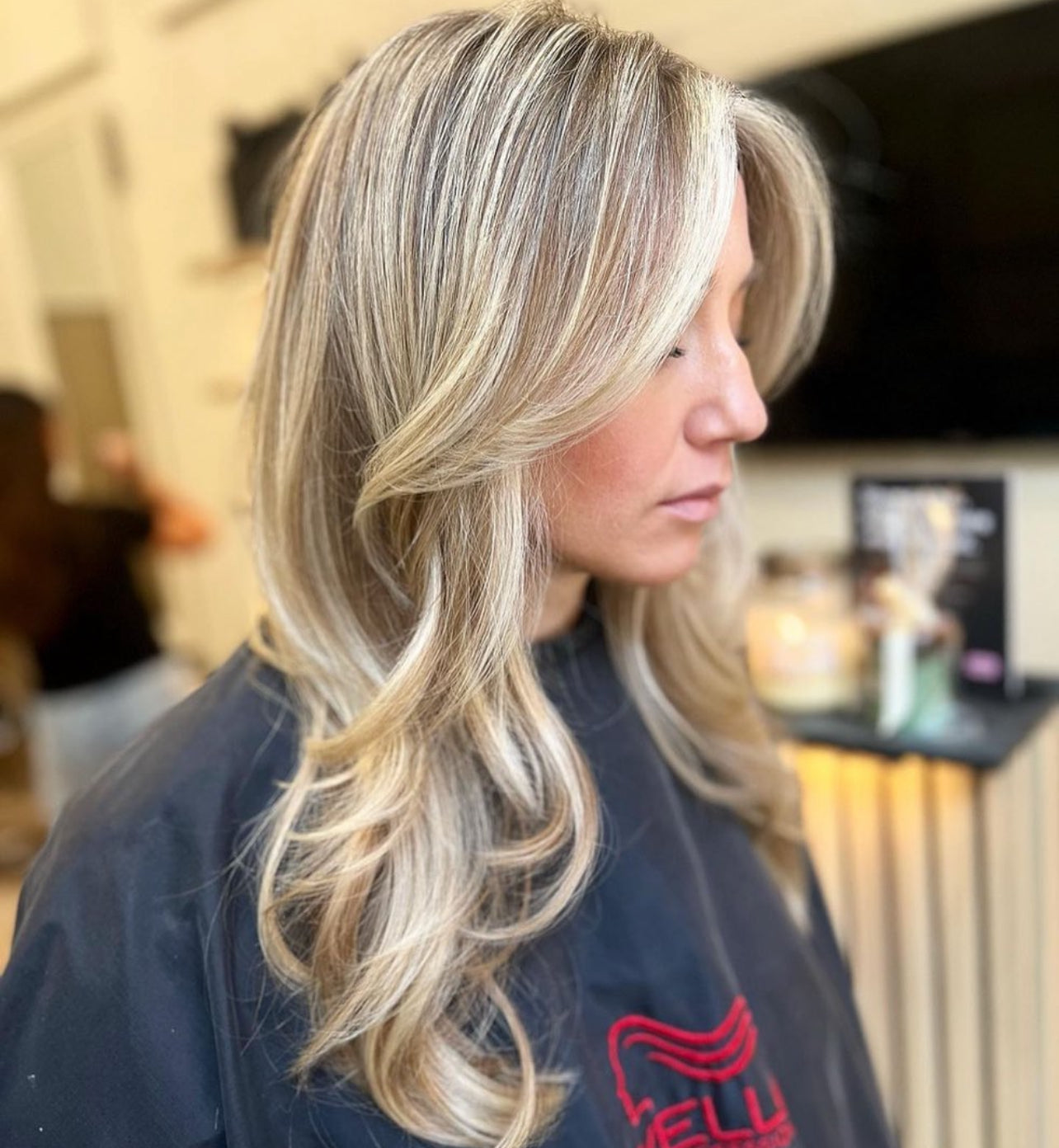 Kvinna med stylat, lockigt hår efter klippning hos LOOKS sthlm